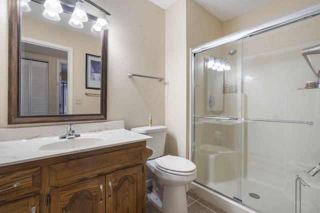 bathroom featuring vanity, tile patterned floors, toilet, a textured ceiling, and an enclosed shower