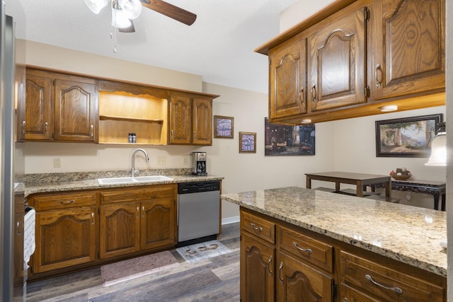 kitchen featuring dishwasher, dark wood-type flooring, sink, ceiling fan, and light stone countertops