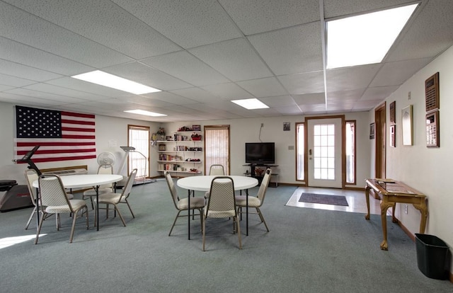 dining area featuring a paneled ceiling and carpet floors