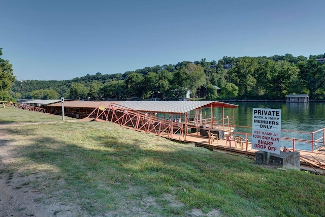 dock area featuring a water view and a lawn