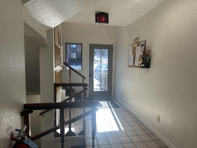 interior space with a textured ceiling and light tile patterned flooring