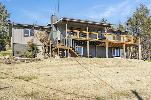 rear view of property featuring stairway, a chimney, and a wooden deck