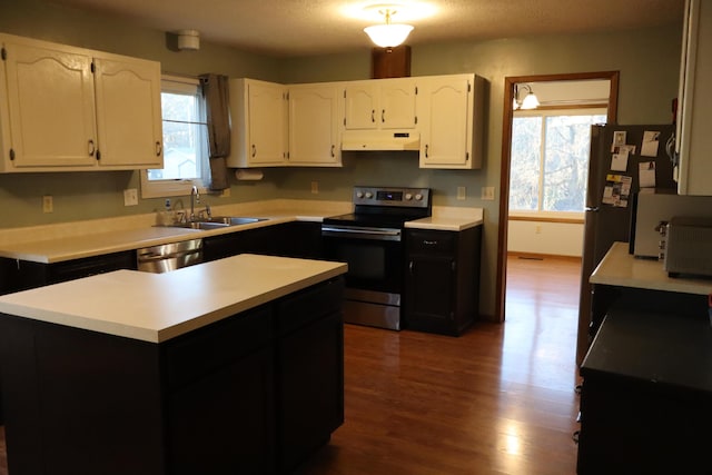 kitchen with hardwood / wood-style floors, a center island, sink, appliances with stainless steel finishes, and white cabinetry