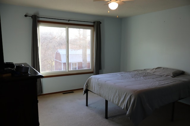 carpeted bedroom featuring ceiling fan and multiple windows