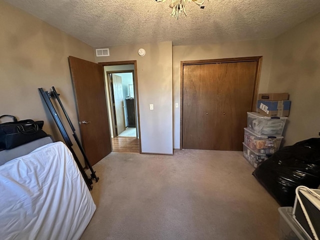 bedroom with a textured ceiling, light carpet, and a closet