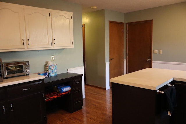 kitchen featuring a kitchen island, dark hardwood / wood-style flooring, and white cabinetry