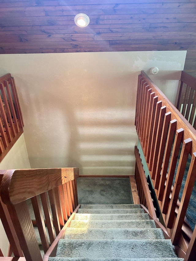 staircase with carpet flooring and wooden ceiling