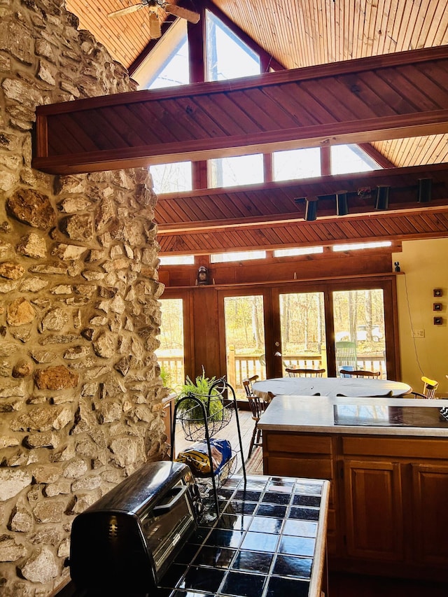 kitchen with ceiling fan, french doors, vaulted ceiling with beams, black cooktop, and wood ceiling