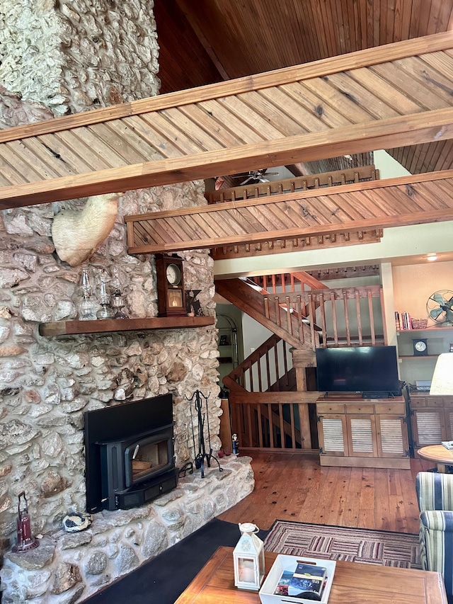 living room featuring hardwood / wood-style flooring, a wood stove, and ceiling fan