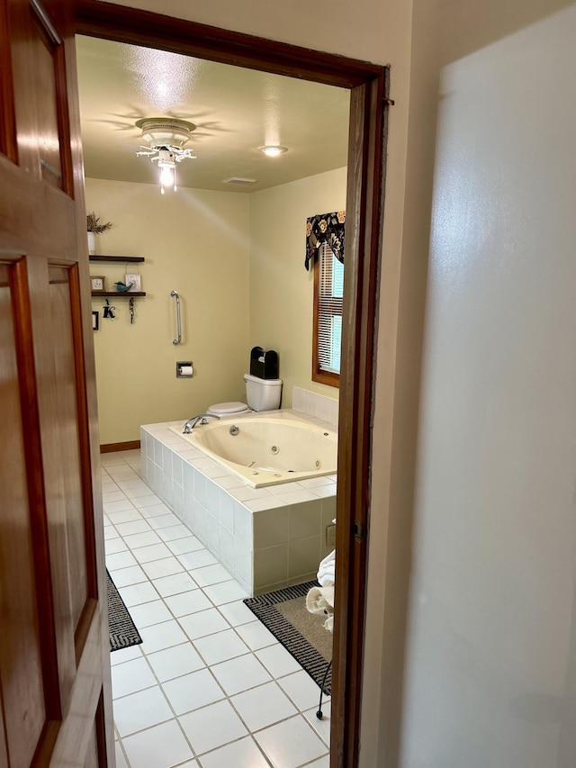 bathroom with tile patterned floors, a textured ceiling, and tiled tub