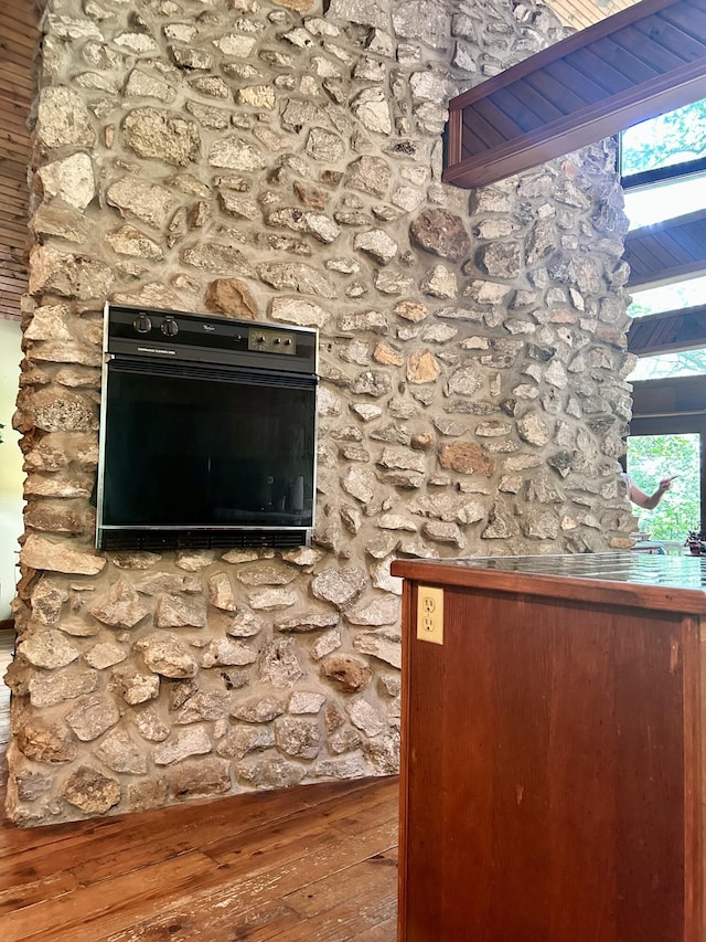 interior details with hardwood / wood-style flooring and black oven