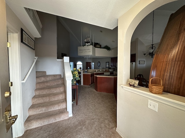 200 Glory Rd Unit C8, Branson, MO 65616 - bar featuring arched walkways, carpet floors, freestanding refrigerator, stairs, and a chandelier