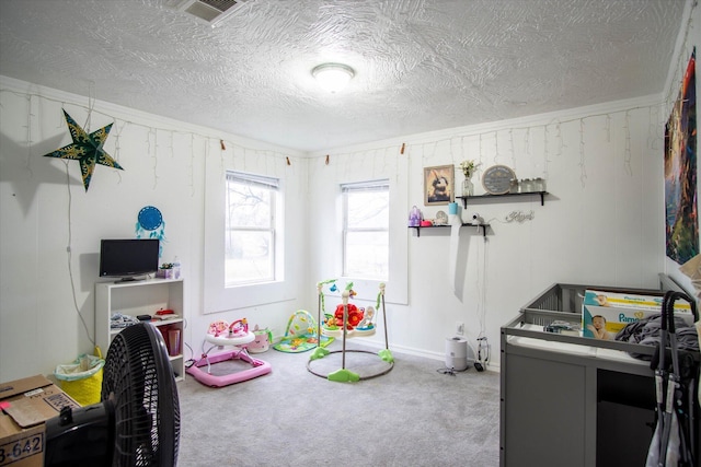 playroom with carpet floors and a textured ceiling