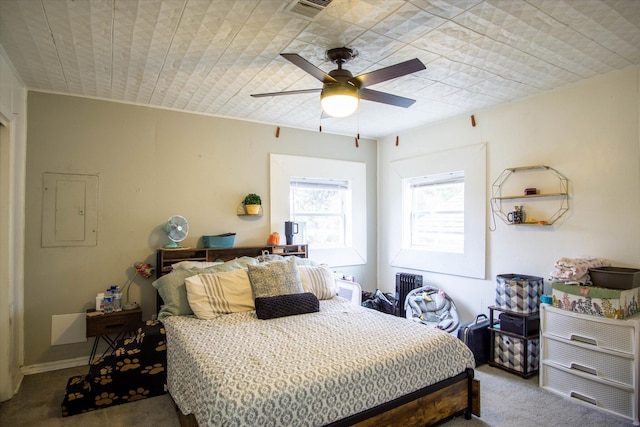 carpeted bedroom with ceiling fan and electric panel