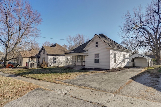 view of front facade featuring a front yard, a carport, and an outdoor structure