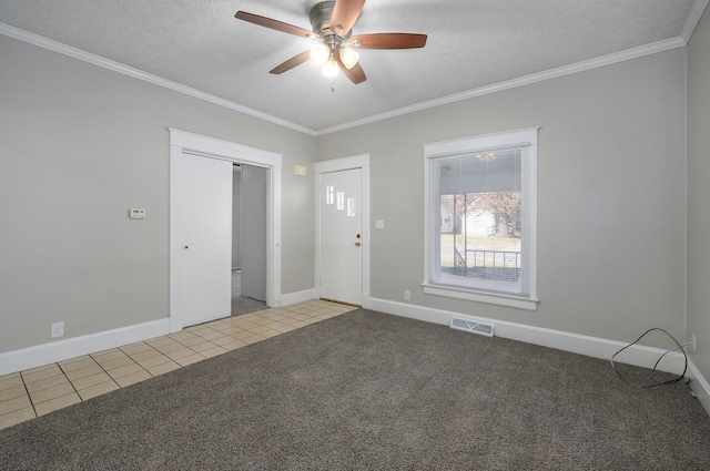 carpeted empty room with ceiling fan, a textured ceiling, and ornamental molding