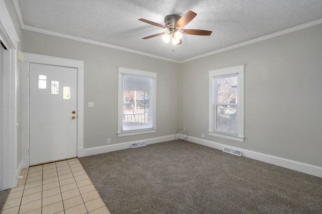 carpeted foyer featuring ceiling fan, a textured ceiling, and ornamental molding