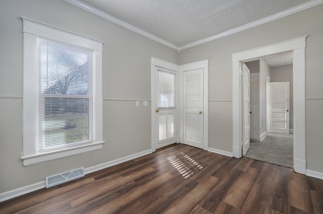 entrance foyer with dark hardwood / wood-style floors, a healthy amount of sunlight, crown molding, and a textured ceiling