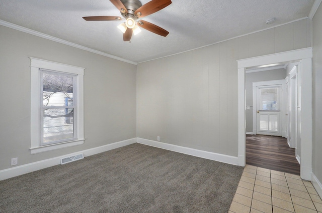 unfurnished room with ceiling fan, crown molding, dark carpet, and a textured ceiling