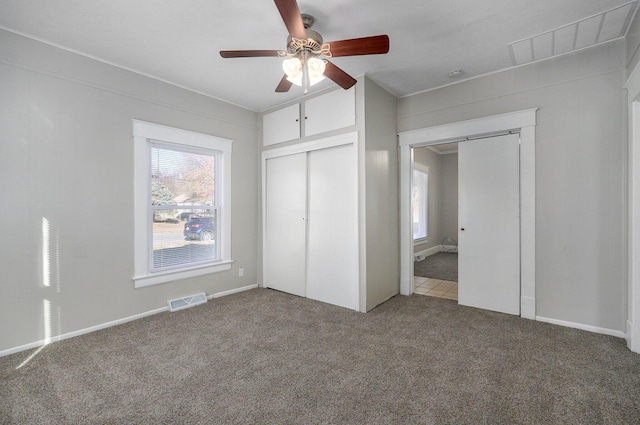 unfurnished bedroom with ceiling fan, a closet, and carpet