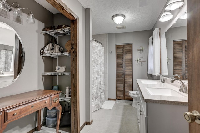 bathroom with vanity, toilet, and a textured ceiling