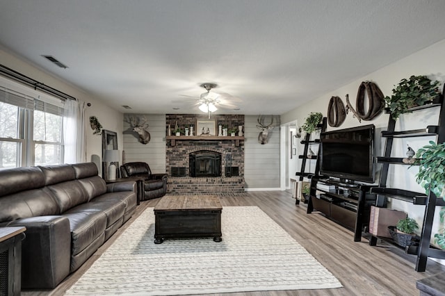 living room with wood walls, hardwood / wood-style floors, and ceiling fan