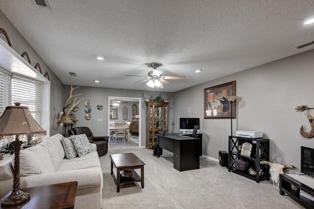 carpeted living room with ceiling fan and a textured ceiling