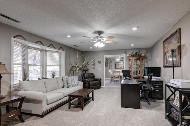 office with a textured ceiling, light colored carpet, and ceiling fan