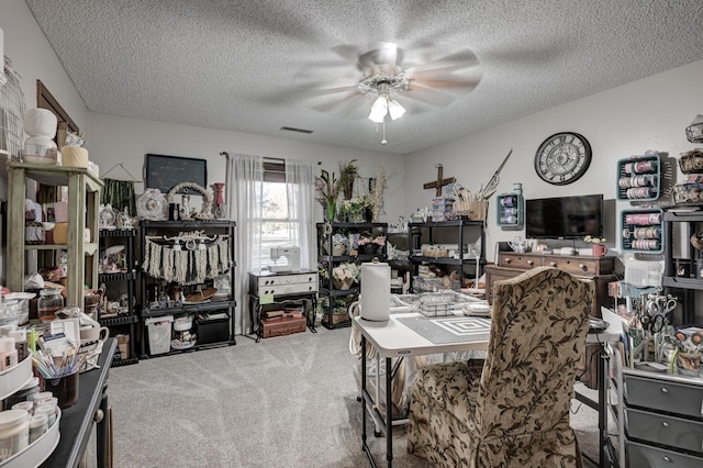 carpeted office space with ceiling fan and a textured ceiling