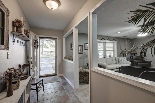 interior space with a textured ceiling and ceiling fan