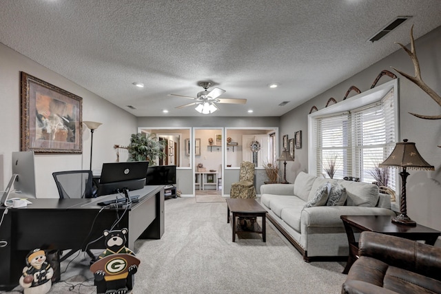 living room with ceiling fan, light colored carpet, and a textured ceiling