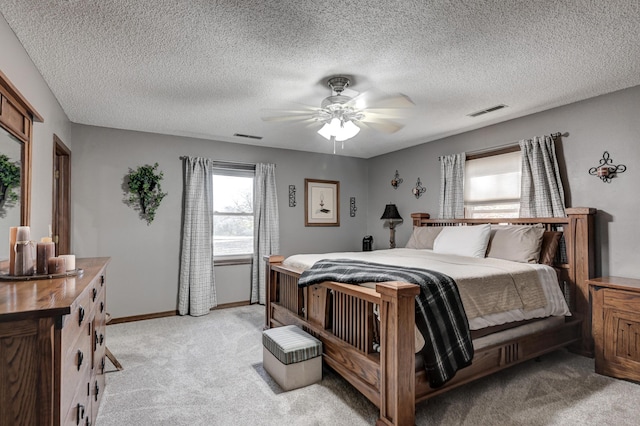 carpeted bedroom with a textured ceiling and ceiling fan