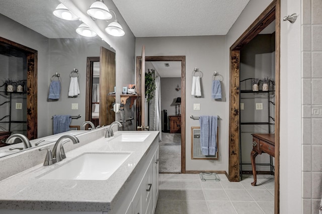 bathroom featuring tile patterned floors, vanity, and a textured ceiling