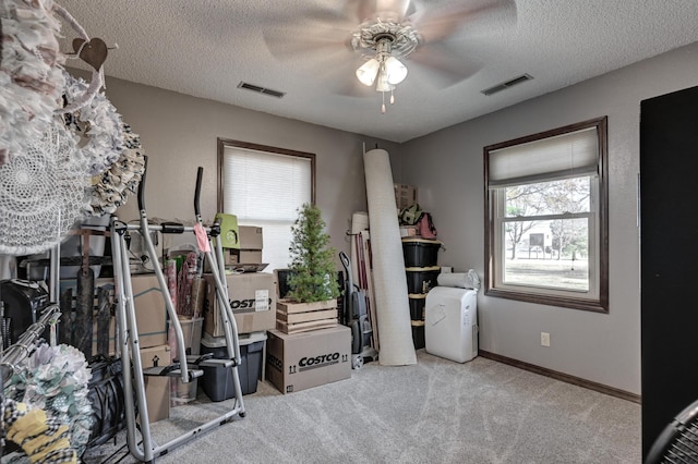 miscellaneous room with a textured ceiling, light colored carpet, and ceiling fan