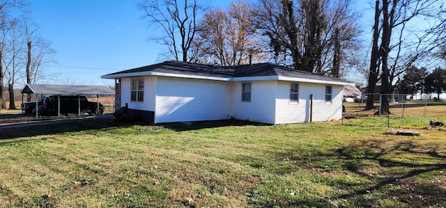 view of home's exterior with a carport and a yard