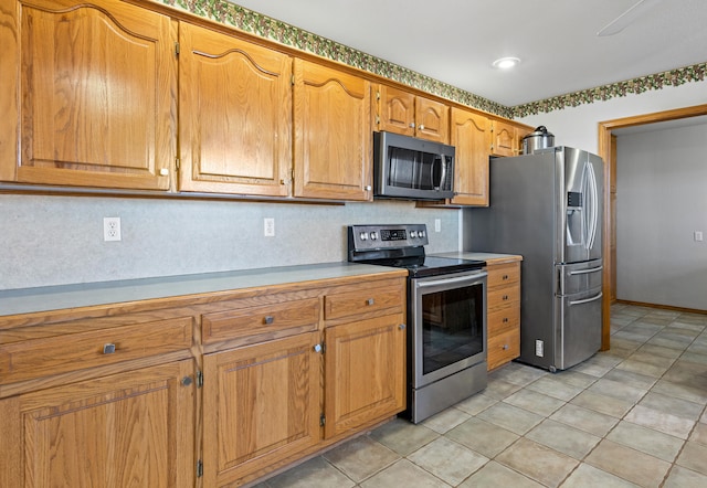 kitchen with light tile patterned floors and stainless steel appliances