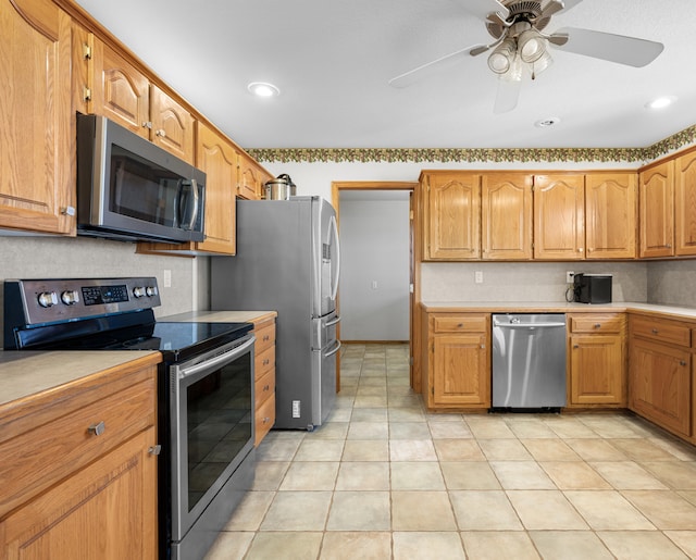 kitchen with ceiling fan, light tile patterned flooring, and stainless steel appliances