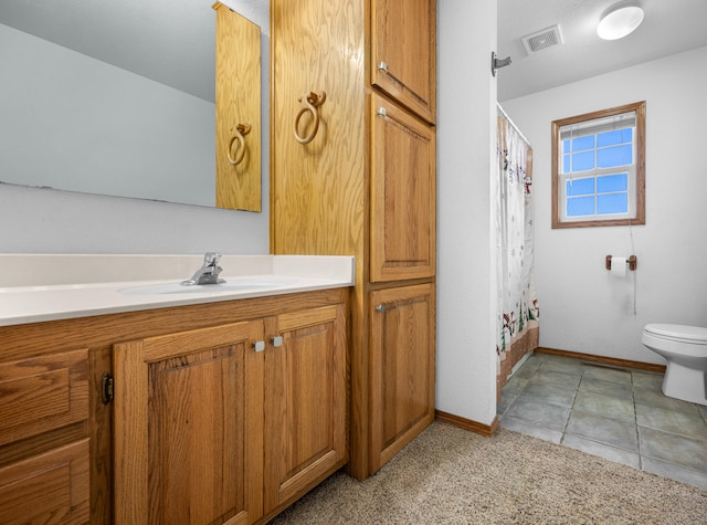 bathroom featuring tile patterned flooring, vanity, and toilet