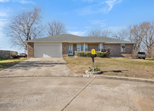 single story home with covered porch, a garage, and a front yard