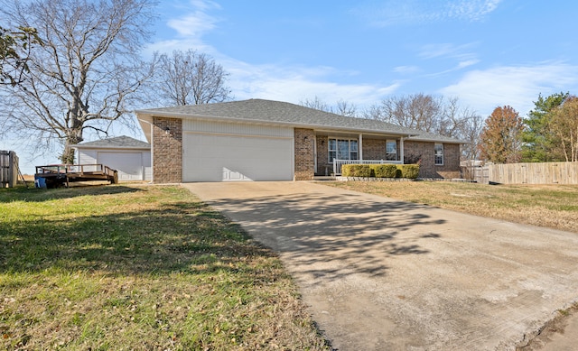 single story home with covered porch, a garage, and a front lawn