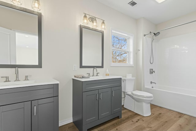 full bathroom with vanity, hardwood / wood-style flooring, toilet, and shower / bathtub combination