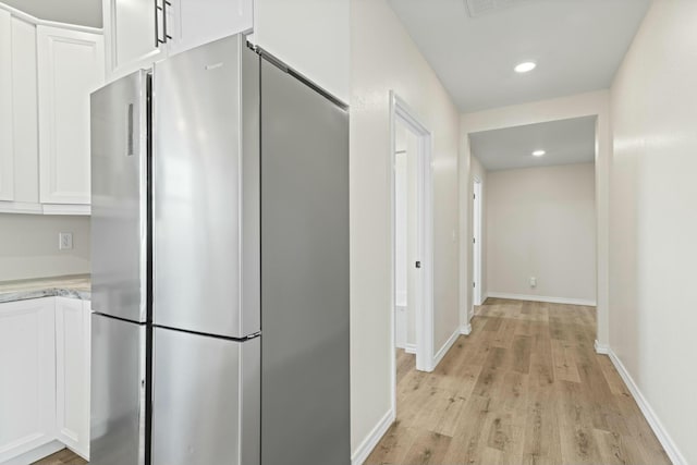 hallway with light hardwood / wood-style floors