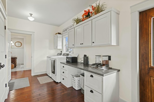 clothes washing area with dark hardwood / wood-style floors, cabinets, and independent washer and dryer