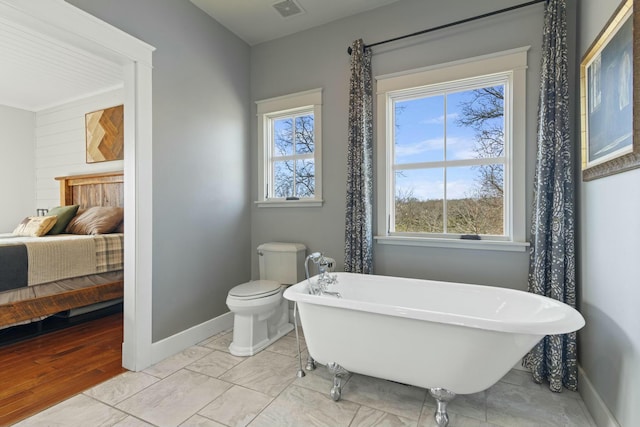 bathroom featuring hardwood / wood-style flooring, toilet, and a bathing tub