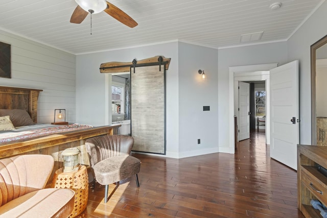 bedroom with dark hardwood / wood-style flooring, ornamental molding, ceiling fan, wooden walls, and a barn door