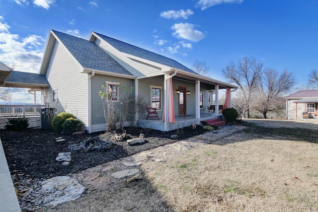 view of side of property featuring covered porch