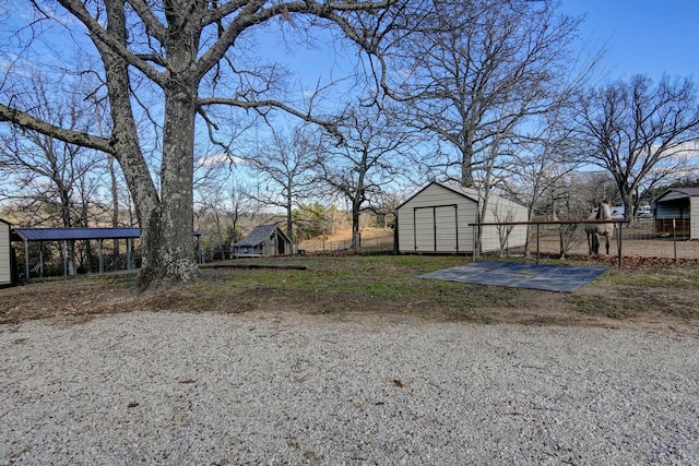 view of yard featuring a carport and an outbuilding