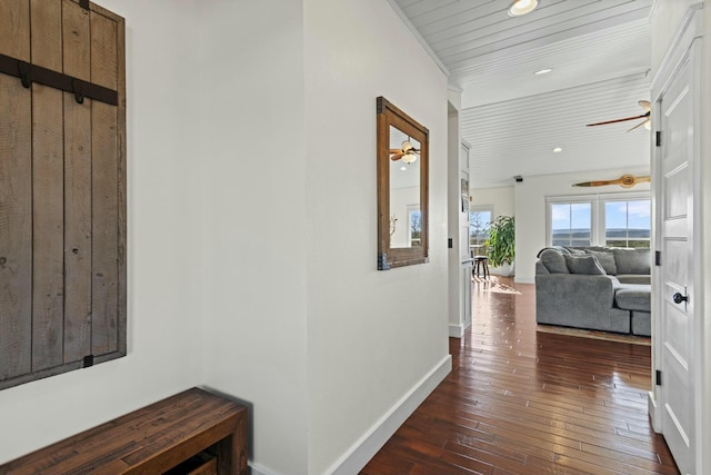 corridor with wooden ceiling, crown molding, and dark wood-type flooring