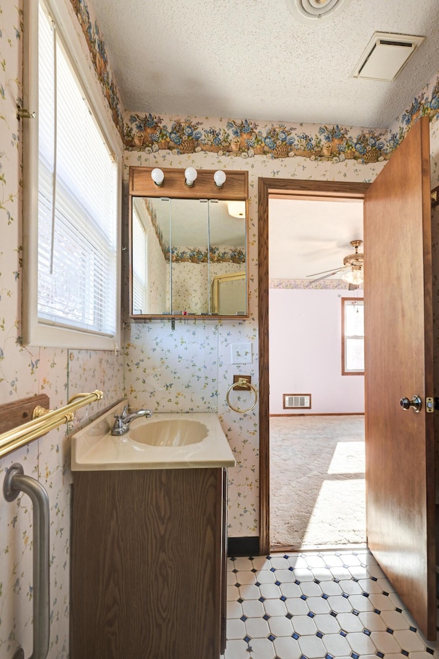 bathroom featuring vanity, a textured ceiling, and ceiling fan