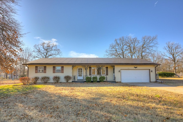 ranch-style home featuring a porch, a garage, and a front yard